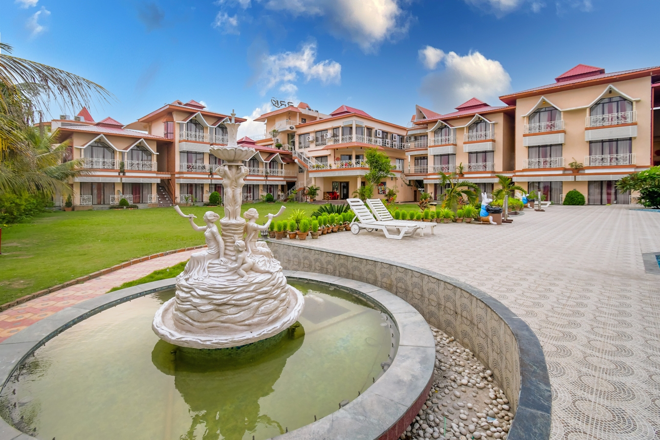 Daytime view of the resort courtyard with fountain and loungers